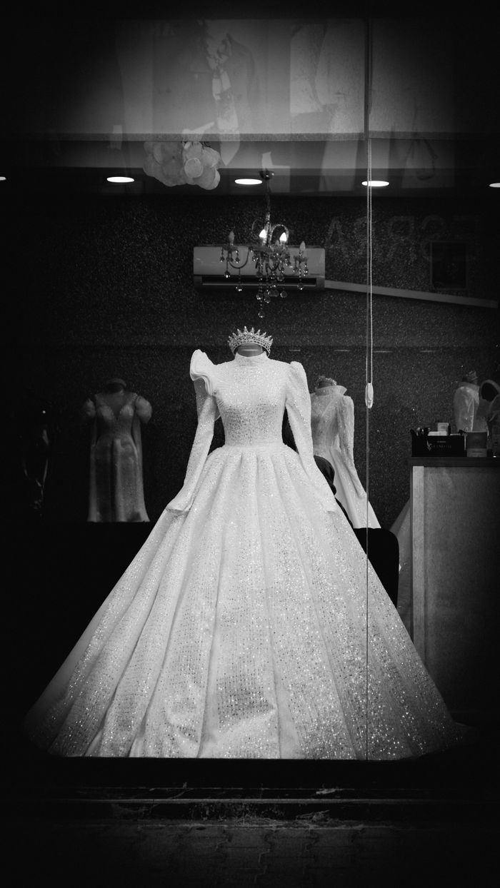 services-09 A stunning wedding dress with intricate details displayed in a boutique window, exuding elegance and style.