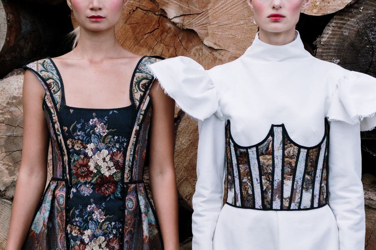 about-05 Two models showcase stylish and elegant fashion designs with floral patterns and dramatic textures.