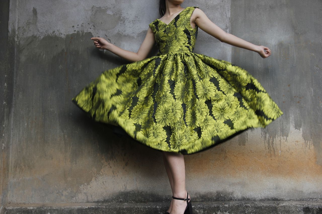 services-10 Woman twirling in a vibrant floral dress capturing movement and style.